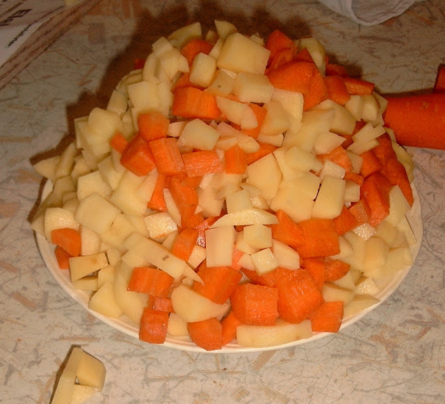 Foto af gulerødder og kartofler i tern lagt fint op i en kegle