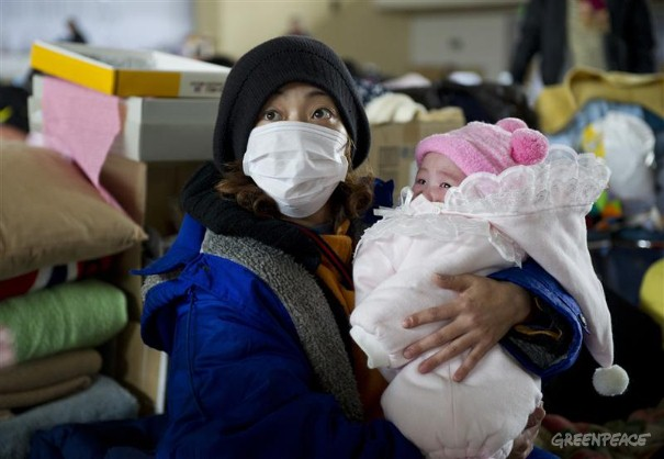 Refugees at Yonezawa Gymnasium in Japan. A mother holds her baby at Yonezawa gymnasium which is now providing a shelter for 504 people who either lost their homes by the Tsunami or live near Fukushima nuclear Power Station. Greenpeace