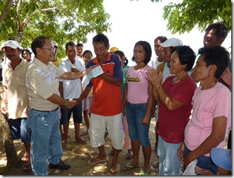 AQD's Mr. Renato Agbayani hands over a check to the officers of a fisherfolk organization in San Antonio