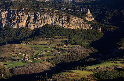 El poblet de Canalda i, darrera, la roca de Canalda, vessant sud de la serra de Querol, port del Comte, Odn, Solsons, Lleida