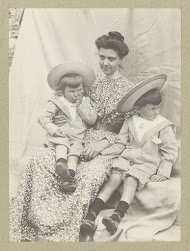 Portret van een vrouw met twee kinderen met zonnehoeden en matrozenpakjes