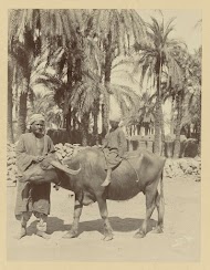 Jongen op een buffel, met man ernaast