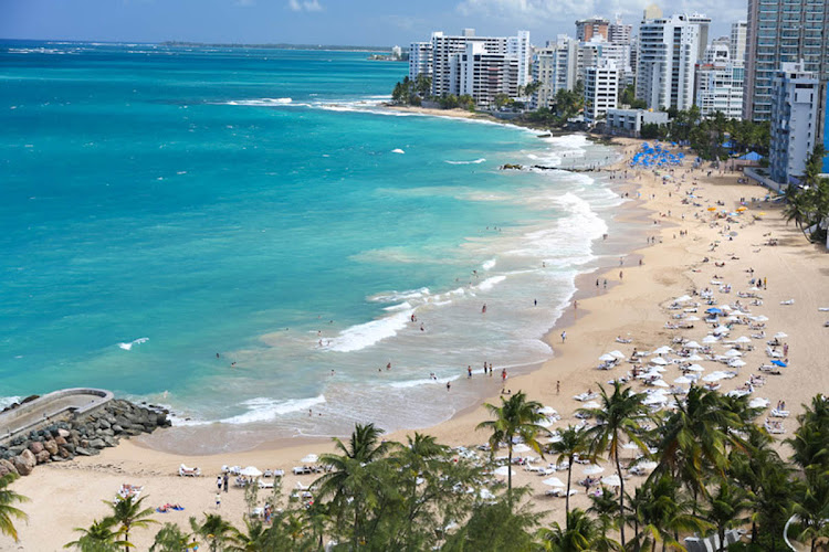 Visitors flock to Isla Verde Beach in Puerto Rico.