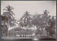 Mannen en vrouwen naast elkaar staand op een weg, vermoedelijk op het terrein van een ziekenhuis in Nederlands-Indië