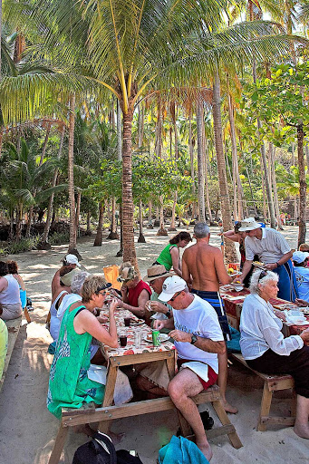 Windstar-Cruises-Tortuga-picnic - Guests of Windstar Cruises enjoy local food and great weather during a picnic on the beach in Tortuga, an island in Haiti. Tortuga is Spanish for turtle or tortoise.