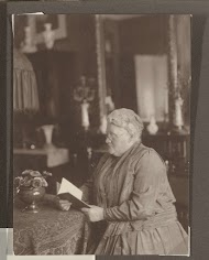 Grietje Vermeulen-Luitjes leest een boek aan tafel