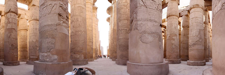 A panoramic view of the Great Hypostyle Hall in Karnak Temple at Luxor, Egypt. Once roofed, it dwarfs visitors with  dozens of colossal columns reaching 75 feet into the sky.