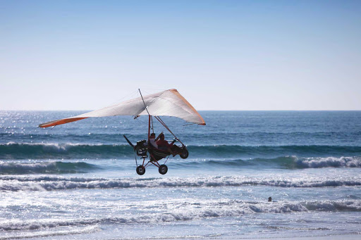 An ultralight plane scoots above the beach in Ensenada, Mexico