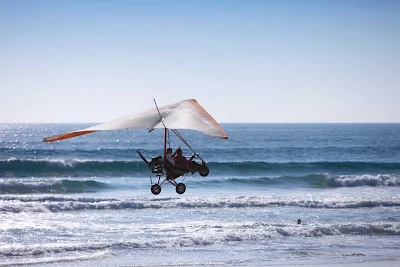 An ultralight plane scoots above the beach in Ensenada, Mexico