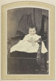 Portret van een baby in een stoel met een ingetekende pop