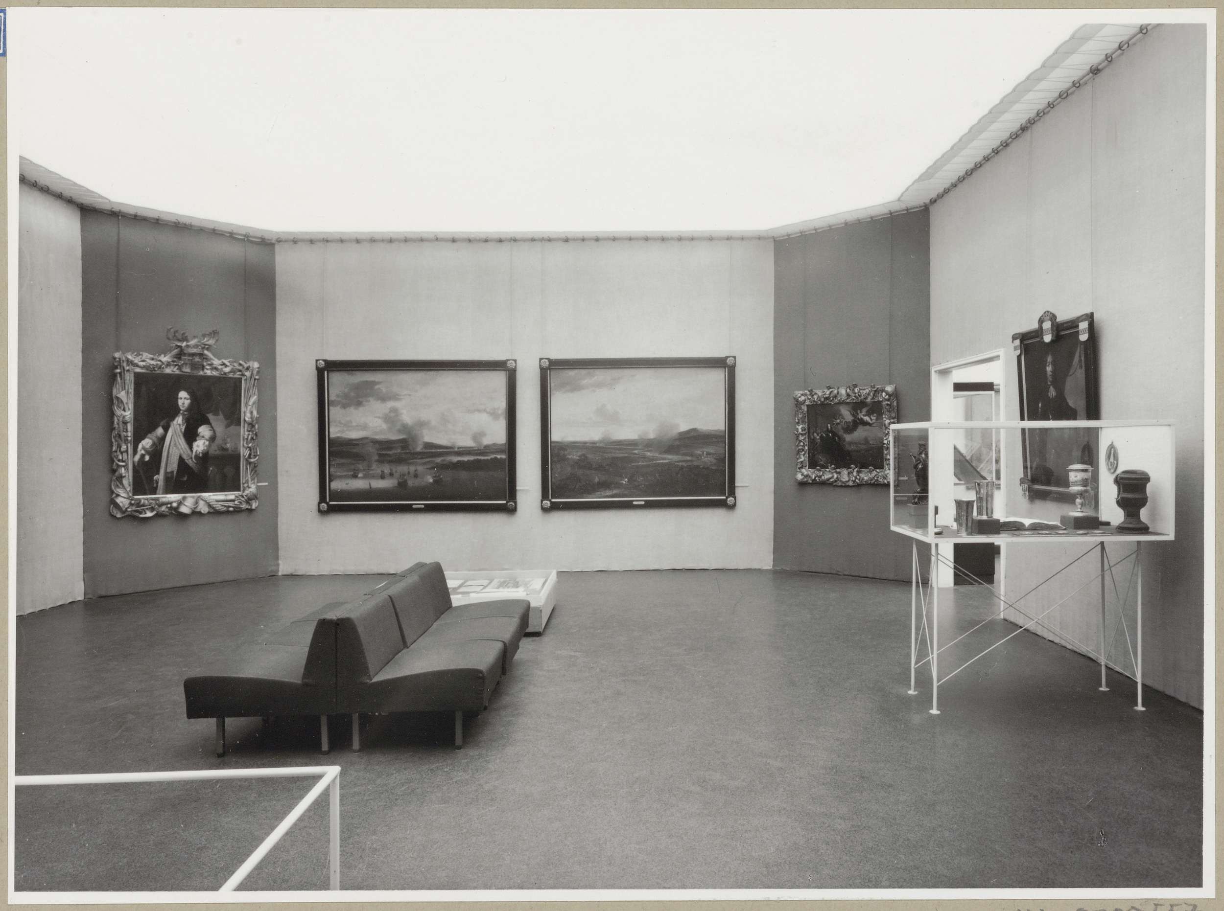Zaal met schilderijen en twee vitrines