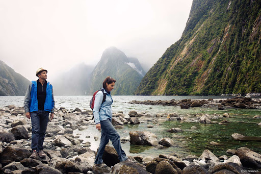 Rock_hopping_Milford_Sound - There’s a prehistoric feel to Milford Sound. The steep cliffs, carved by an ancient glacier, are draped in native forest and ferns. High waterfalls plummet from river valleys, creating streaks of white amid the green.  