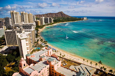 A wide shot of Waikiki Beach in Honolulu with Diamond Head in the distance.