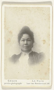 Studioportret van een vrouw met opgestoken haar en oorbellen