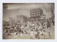 Badgasten aan het strand van Brighton, op de achtergrond hotels en restaurants