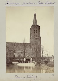 Mensen in klederdracht poserend voor de kerktoren van Kloetinge