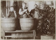 Brouwer en bedienden reinigen flessen bij een flessendroogrek