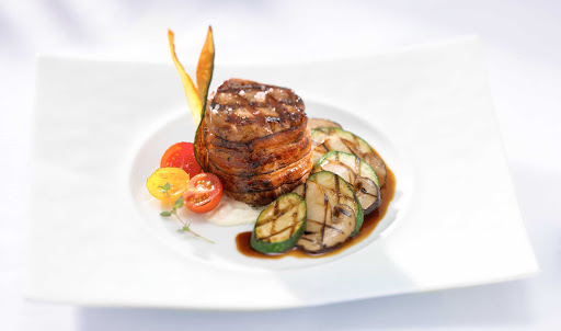Blu Charred Veal Loin - Blu Restaurant's charred grilled veal loin served with sweet cherry tomatoes, sliced zucchini and drizzled with a rich jus is just one of the appetizing main courses served during your Celebrity Cruises voyage.