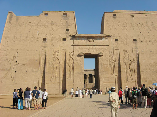 Edfu, Egypt, located on the west bank of the Nile. The town is known for the Temple of Horus, built from sandstone blocks between 237 BC and 57 BC, into the reign of Cleopatra VII, Wikipedia tells us. 