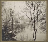 Huis in ondergelopen buitenwijk van Parijs gezien door kale bomen