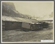 Barak met geparkeerde ambulancesleeën, één heeft een rood kruis