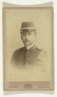 Studioportret van een man met snor, baard en bril in leger uniform