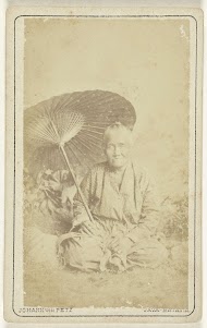 Studioportret van een oude Javaanse dame onder een parasol