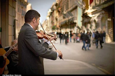 A pinstriped violinist on Via del Corso in Rome.