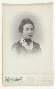 Studioportret van een vrouw in zwarte jurk met wit kanten kraag