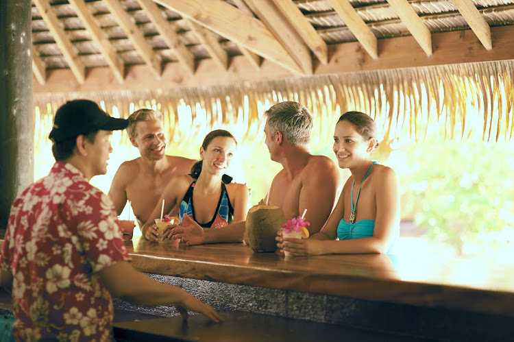 Paul Gauguin guests relax at the bar on the beach at Motu Mahana, a tiny island off Taha'a in the Society Islands.