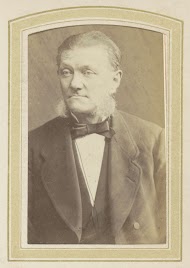 Portret van een man met bakkebaarden, een strikje en een jas