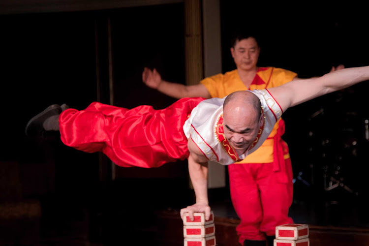 A member of the Hong Kong Folkloric troupe displays an impressive feat of strength and balance during a performance on an Azamara cruise.